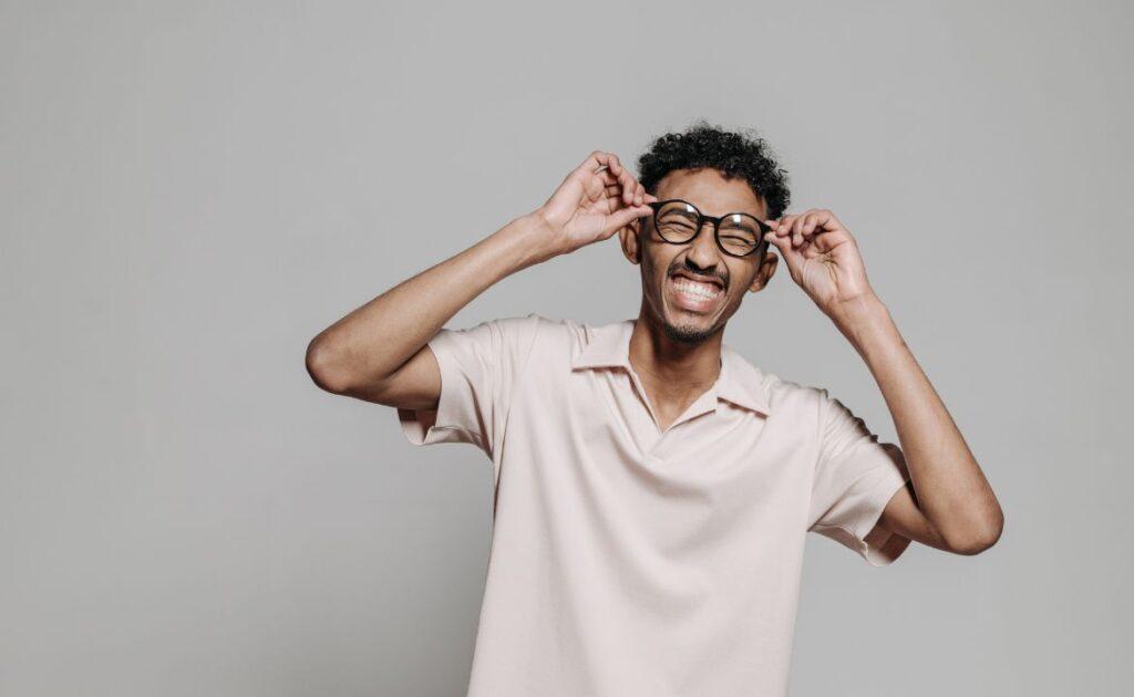 A stylish person wearing light gold rectangular glasses, paired with a neutral-toned outfit, showcasing how to style the frames for a chic look.